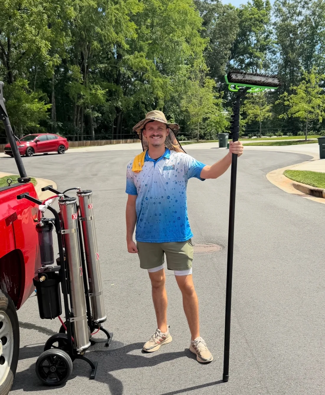 Andrew of Diamond Residential with a water-fed pole beside the work truck.
